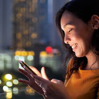 Young Asian Woman Using Smart Phone in the City at night